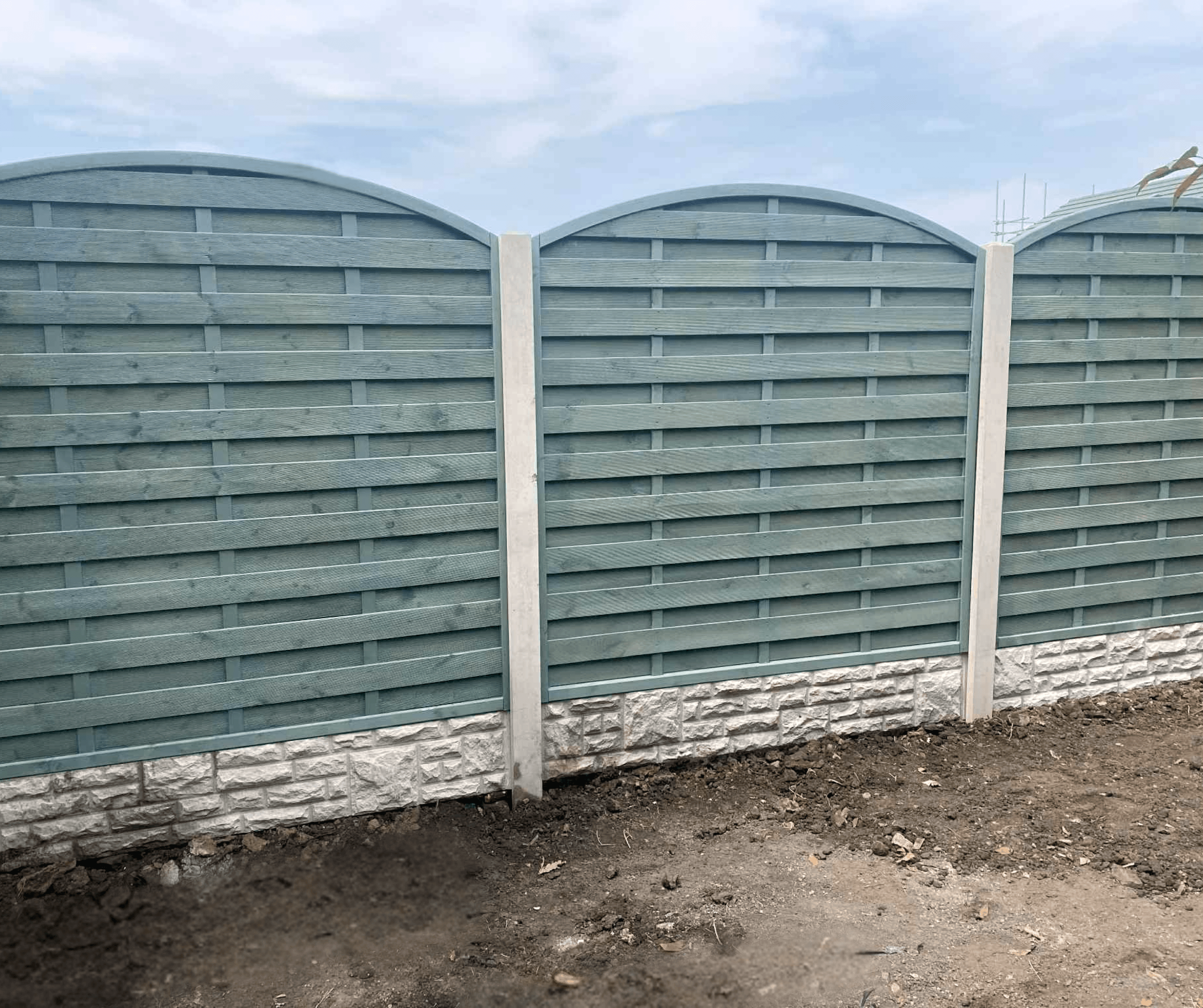 Arched grey fence panels set between concrete posts