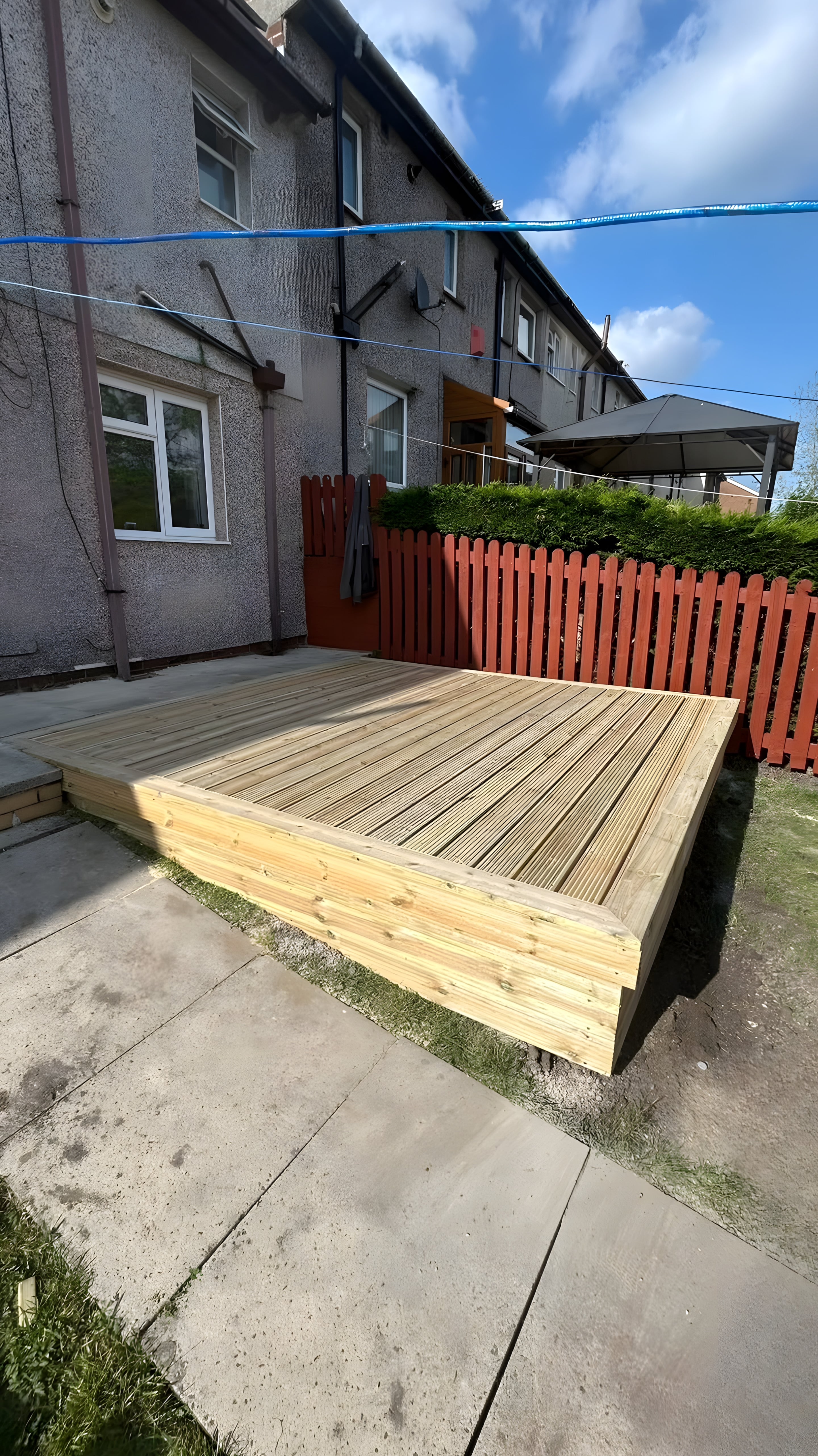 Low raised timber deck with grooved boards beside a garden path